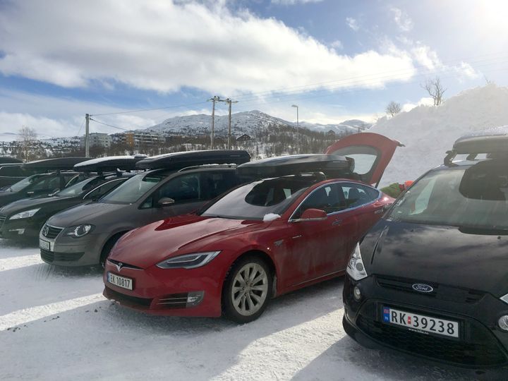 Tesla Model S er en av 22 elbilmodeller som fikser last på taket. Her er den  i godt takboks-selskap på norsk skidestinasjon til fjells.