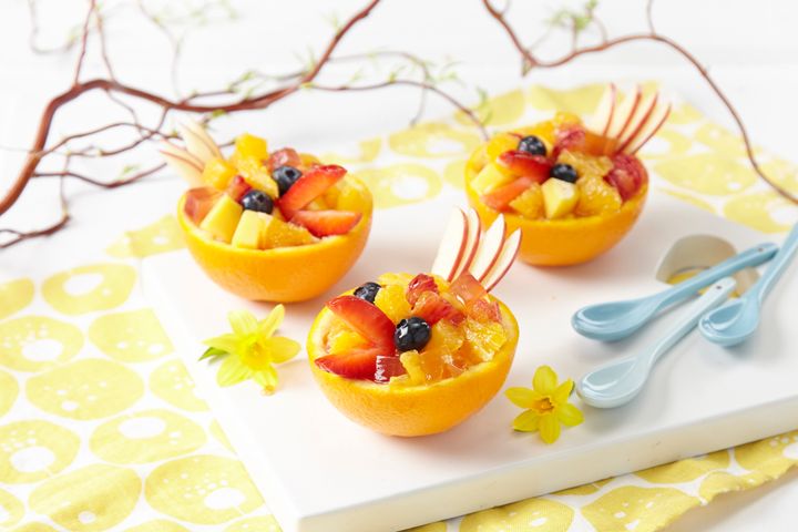 Enkel og festlig påskedessert: Server fruktsalat med appelsiner i halve appelsinskall. Lag nebb av jordbær, blåbærøyne og eplestjert.