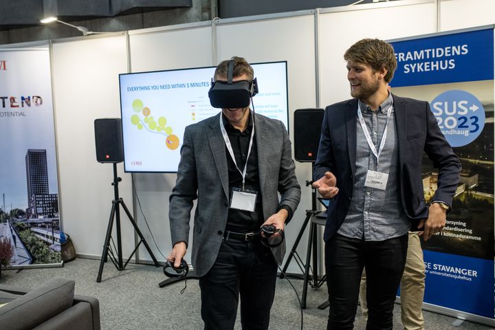 Ingeniør Kristoffer Tungland (til høyre) guider besøkende rundt i VR.studioet. Her inne kan VR-brukerne møte avatarene til andre mennesker som besøker modellen - fra et helt annet sted i landet. Foto: COWI
