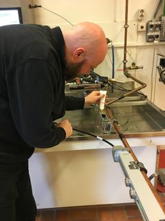 Bjørn Ludvigsen tester måleutstyr for bruk av varmtvann hos SINTEF Byggforsk. Utstyret vil nå plasseres i utvalgte bygg. Foto: SINTEF