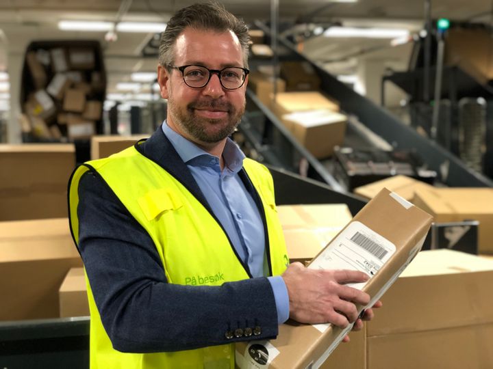 Pressesjef John Eckhoff i Posten Norge med en av 200.000 pakker som skal gjennom  Logistikksenter Oslo i dag. FOTO: Posten
