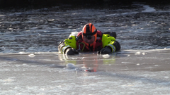 Fagsjef Matt Skuse i Redningsselskapet drar seg opp på isen i vannrett stilling.