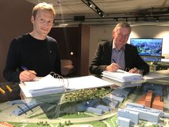 Kontrakten signeres i visningssenteret på Ulven, f.v.: Espen Stordal (Team Veidekke DA) og Nils Morten Bøhler (OBOS Forretningsbygg AS)