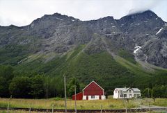 Mannen troner høyt over Romsdalen, hele 1294 meter over havet. Lengst oppe, hvor skredene utløses, er det stupbratt. Under ligger skredmassene som nå er datert. I forgrunnen ligger skinnegangen til Raumabanen.