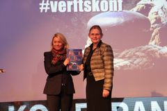 Leder av strategigruppa, Siri Pettersen Strandenes (til høyre), overleverer Maritim21-strategien til næringsminister Monica Mæland under åpningen av Verftskonferansen i Ålesund