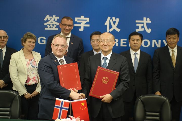 Fiskeriminister Per Sandberg signerte 23. mai 2017 en protokoll om eksport av laks fra Norge til Kina med ministeren for Kinas veterinærmyndigheter. Foto: NFD
