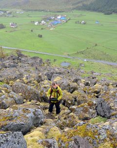 Forsker Kari Sletten står i ei steinur under Guratinden i Sennesvik i Lofoten. Her kartlegger hun alt hun ser i skråningen og undersøker blant annet gamle skredbaner.