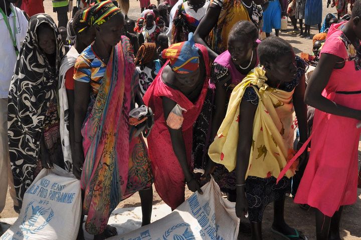 Kvinner i Ganyiel i Sør-Sudan samler poser med mat. Situasjonen i Ganyiel er prekær, tusenvis av mennesker har flyktet til dette området fra nærliggende sultrammede fylker. Foto: OCHA / Gemma Connell