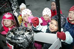 Barn gir gaver til Frelsesarmeens Julegryte.