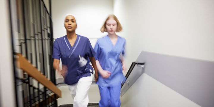 To sykepleiere løper opp en trapp.