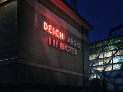 Nå lyser «DEICH» i rødt ned på byggeplassen til det nye regjeringskvartalet og over byen, som et tegn på hva som er i vente.