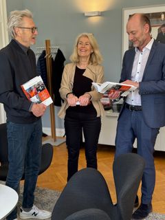 Redaktør Harald Engestad, styreleder Grete Brochmann og direktør Knut Olav Åmås mottar boken.