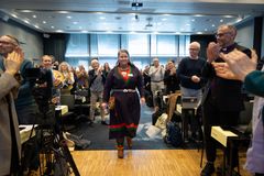 Den nye lederen for Samisk kirkeråd klappes opp på talerstolen på Kirkemøtet.